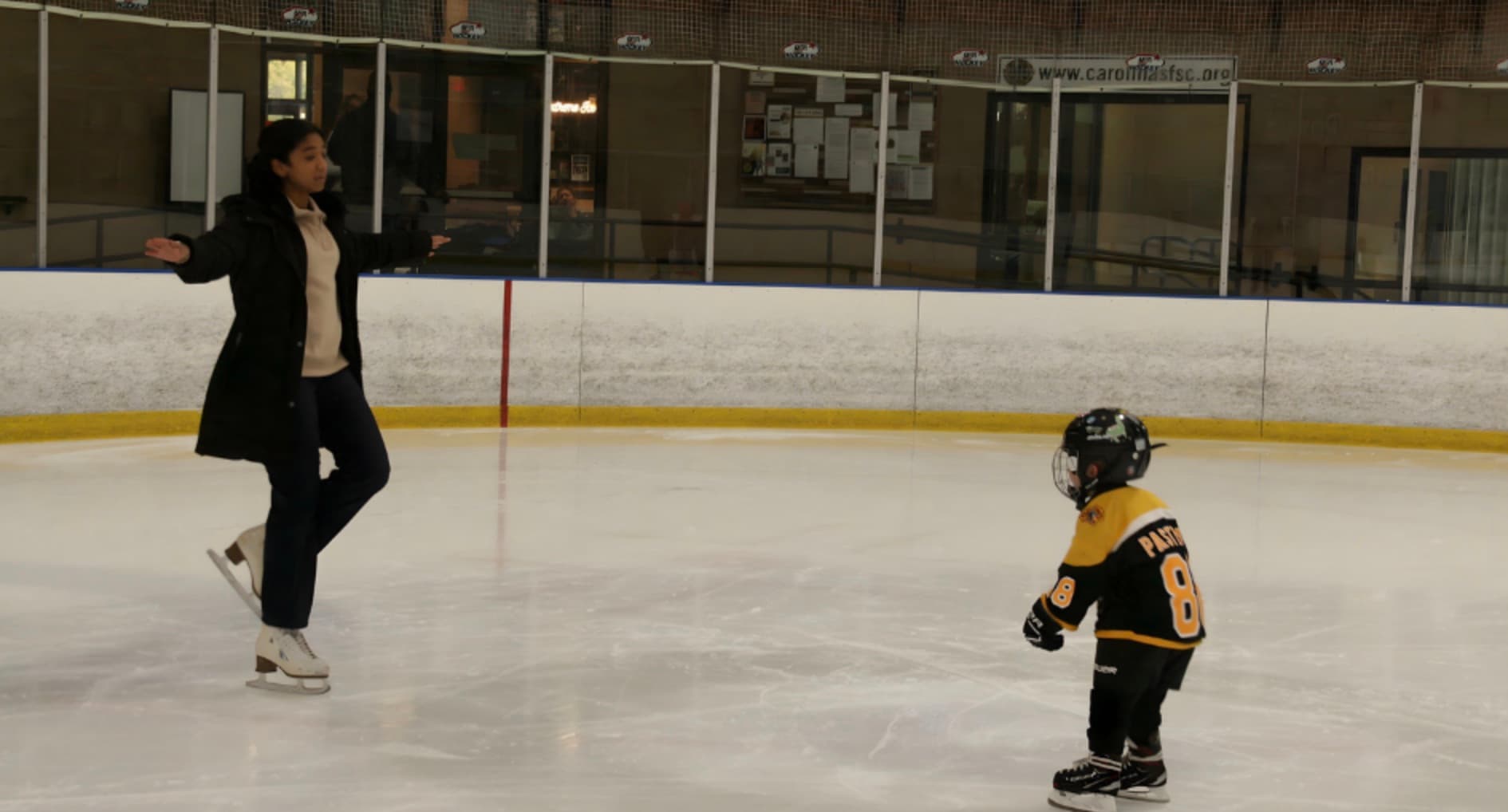 Coach Sami demonstrating an edge on the ice for a young skater